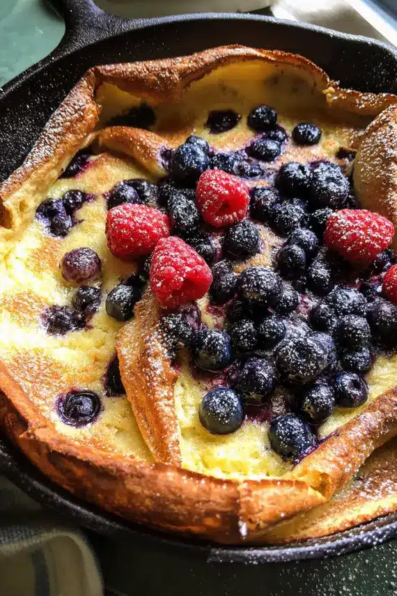 Perfectly puffed lemon dutch baby pancake with berries fresh from the oven