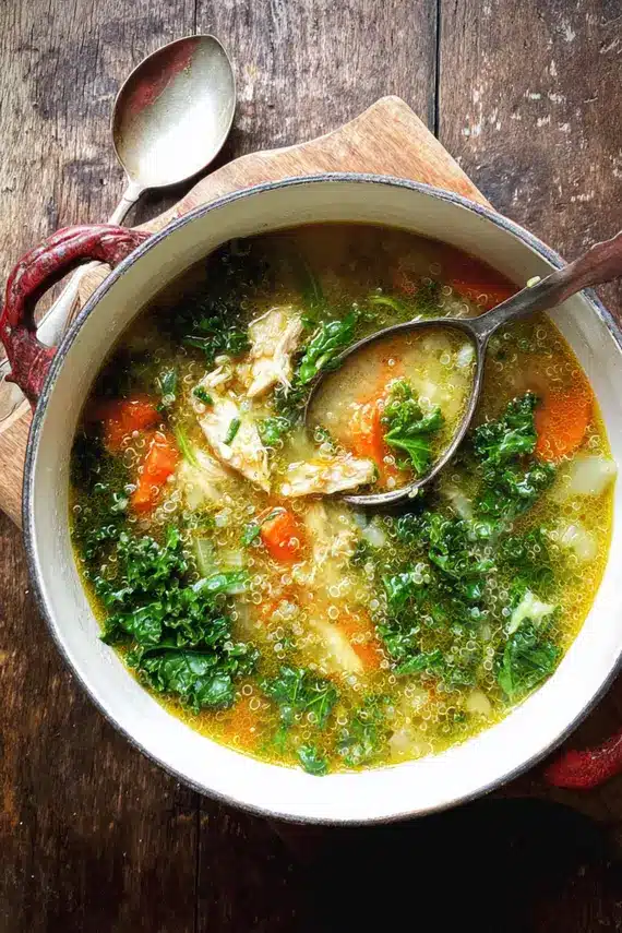 Green Chicken Quinoa Soup garnished with fresh herbs