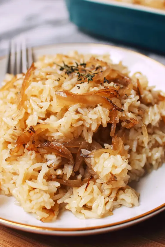 French onion butter rice served as a side dish with protein and vegetables showing the perfect golden color