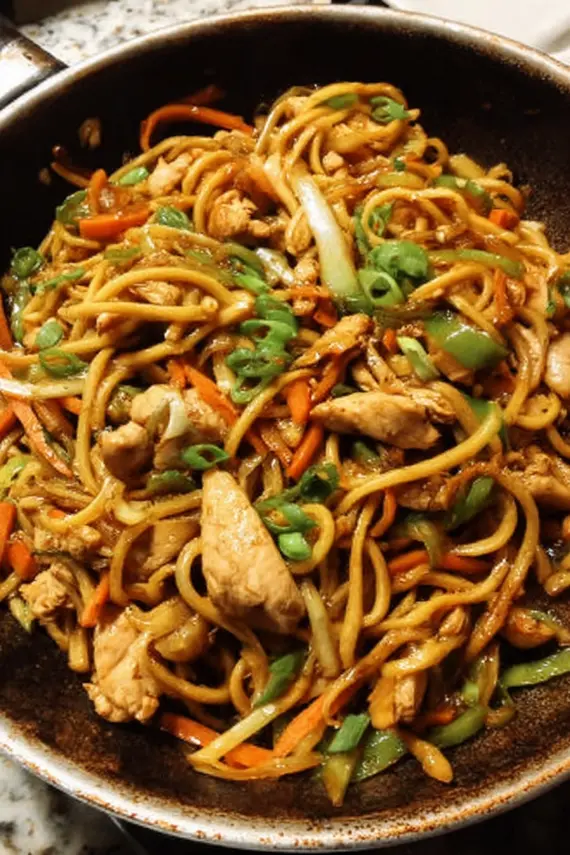 Homemade chicken lo mein served in a bowl with chopsticks