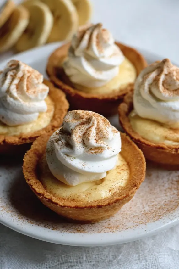 Freshly prepared mini banana pudding pies with whipped cream topping