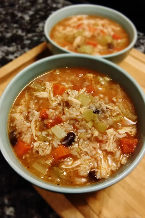 Steaming bowl of homemade chicken bean rice soup with colorful vegetables