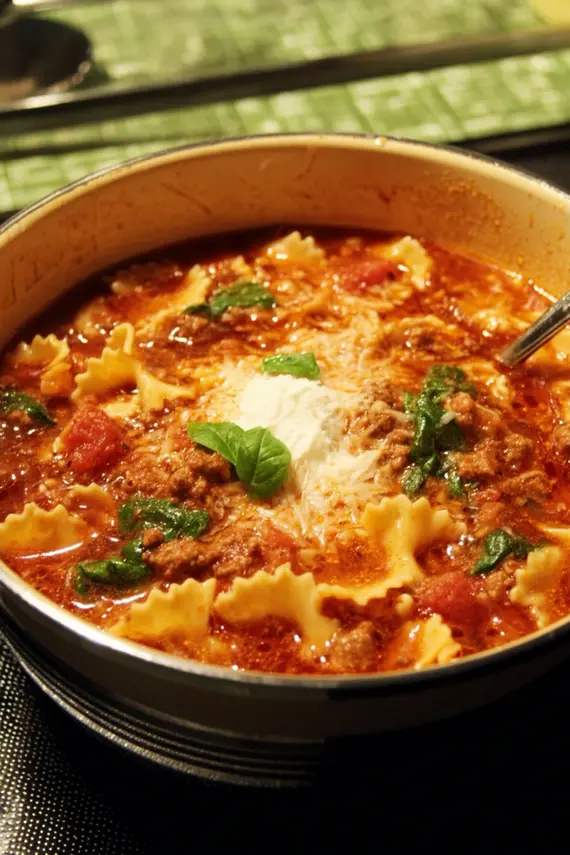 Steaming hot lasagna soup one pot with melting cheese and fresh herbs