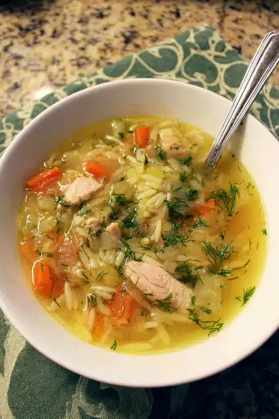 Bowl of chicken fennel orzo soup with rustic bread