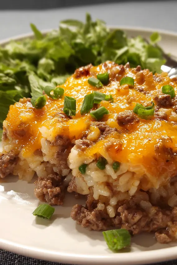Beef rice casserole with cheddar served with a side salad and garlic bread