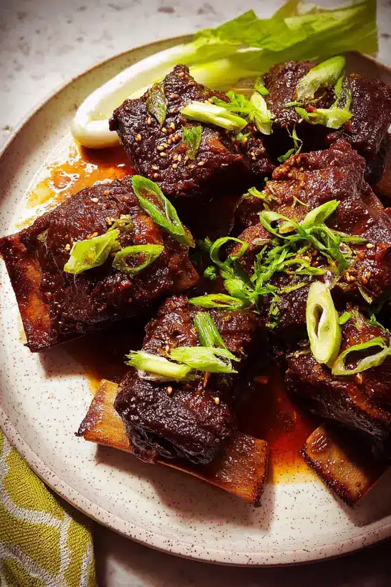 Soy braised beef short ribs served with sides and garnish